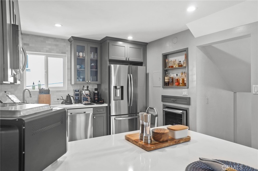 11954 Goshen Avenue, Unit 205 Los Angeles, CA 90049 - Photo 22 of 48 a kitchen with stainless steel appliances kitchen island granite countertop a refrigerator a sink a stove with wooden floor
