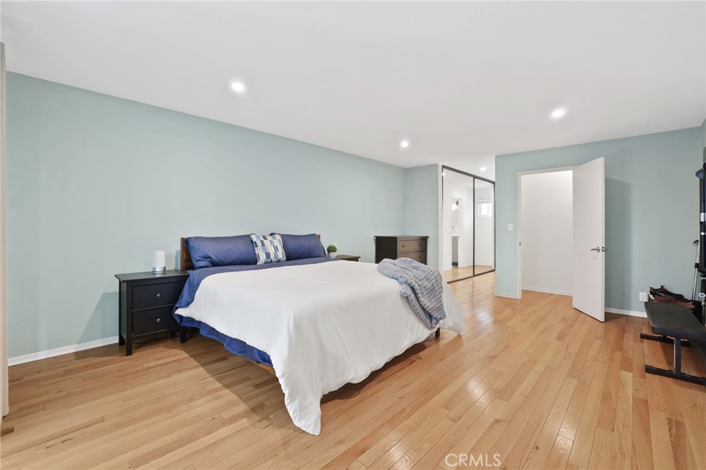 11954 Goshen Avenue, Unit 205 Los Angeles, CA 90049 - Photo 34 of 48 a spacious bedroom with a bed and a wooden floor