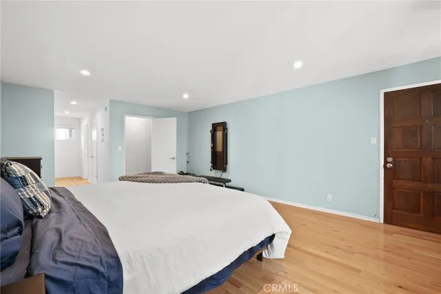 a spacious bedroom with a bed and a wooden floor