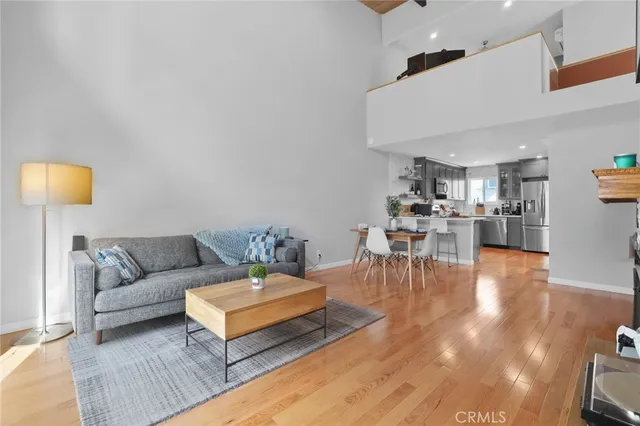 a living room with furniture and a dining table with kitchen view