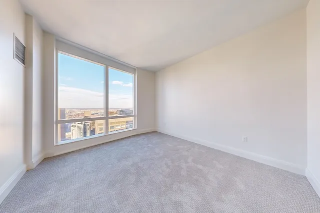an empty room with windows and city view