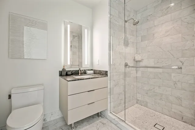 a bathroom with a sink a toilet and shower