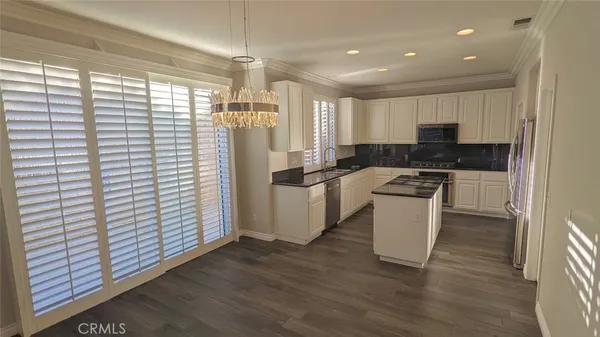 a kitchen with a refrigerator and white cabinets