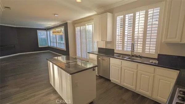 a kitchen with granite countertop sink stove and cabinets