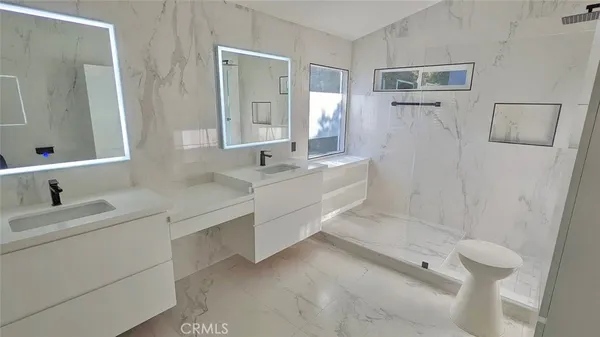 a bathroom with a double vanity sink toilet mirror and bathtub