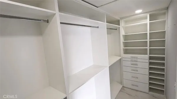 a view of walk in closet with empty racks