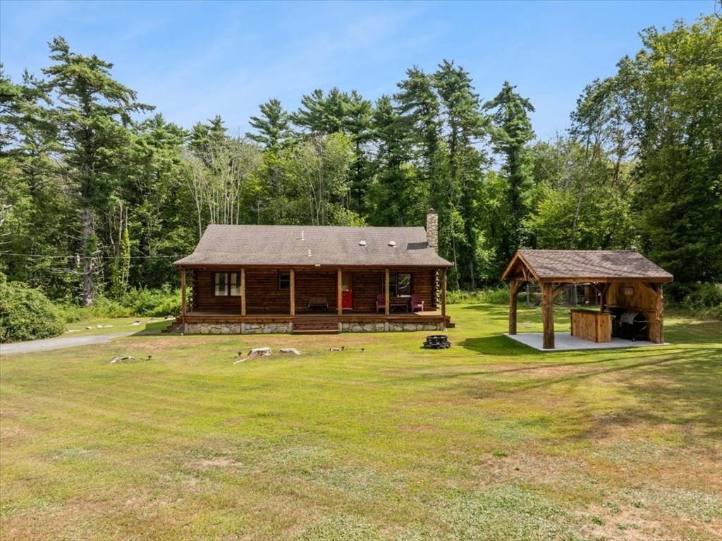 148 Braley Hill Road Rochester, MA 02770 - Photo 1 of 41 a view of a swimming pool with lawn chairs and large trees