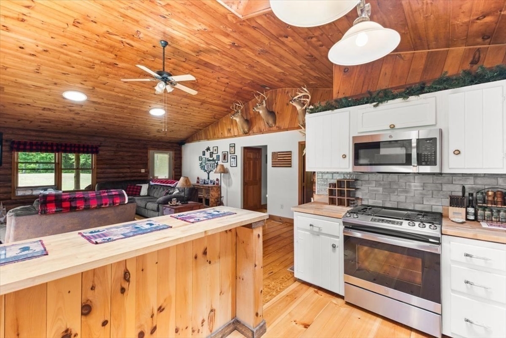 148 Braley Hill Road Rochester, MA 02770 - Photo 19 of 41 a kitchen with a stove a microwave and a table