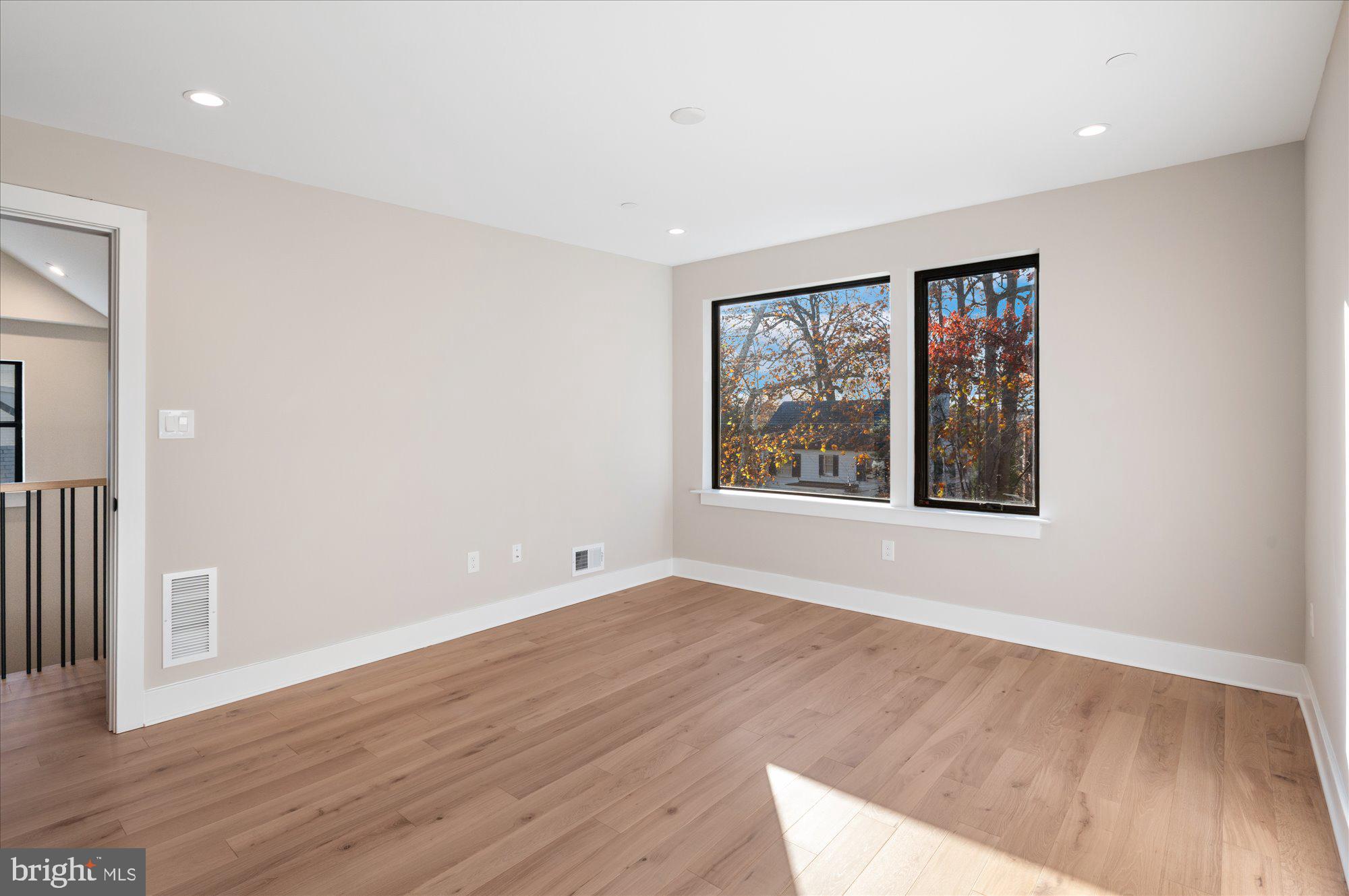 5445 33rd Street Northwest Washington, DC 20015 - Photo 40 of 72 a view of an empty room with wooden floor and a window