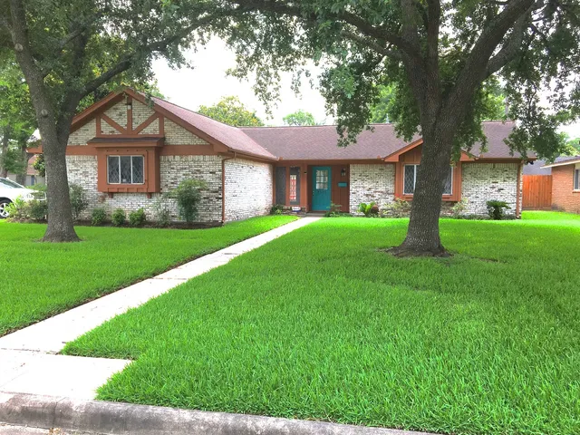 a front view of a house with a yard and trees