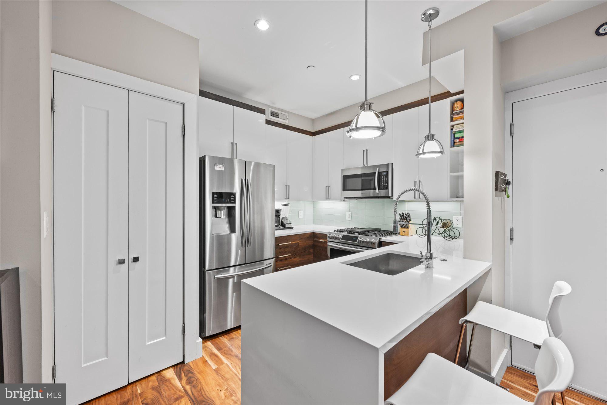 1337 K Street Southeast, Unit 101 Washington, DC 20003 - Photo 3 of 12 a kitchen with white cabinets and stainless steel appliances