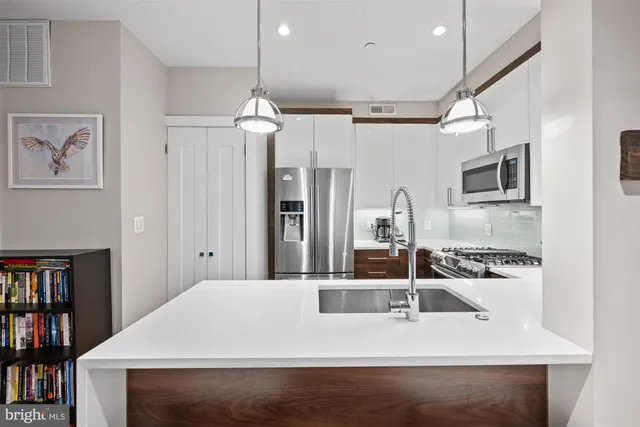 a kitchen with kitchen island a sink appliances and a counter top space