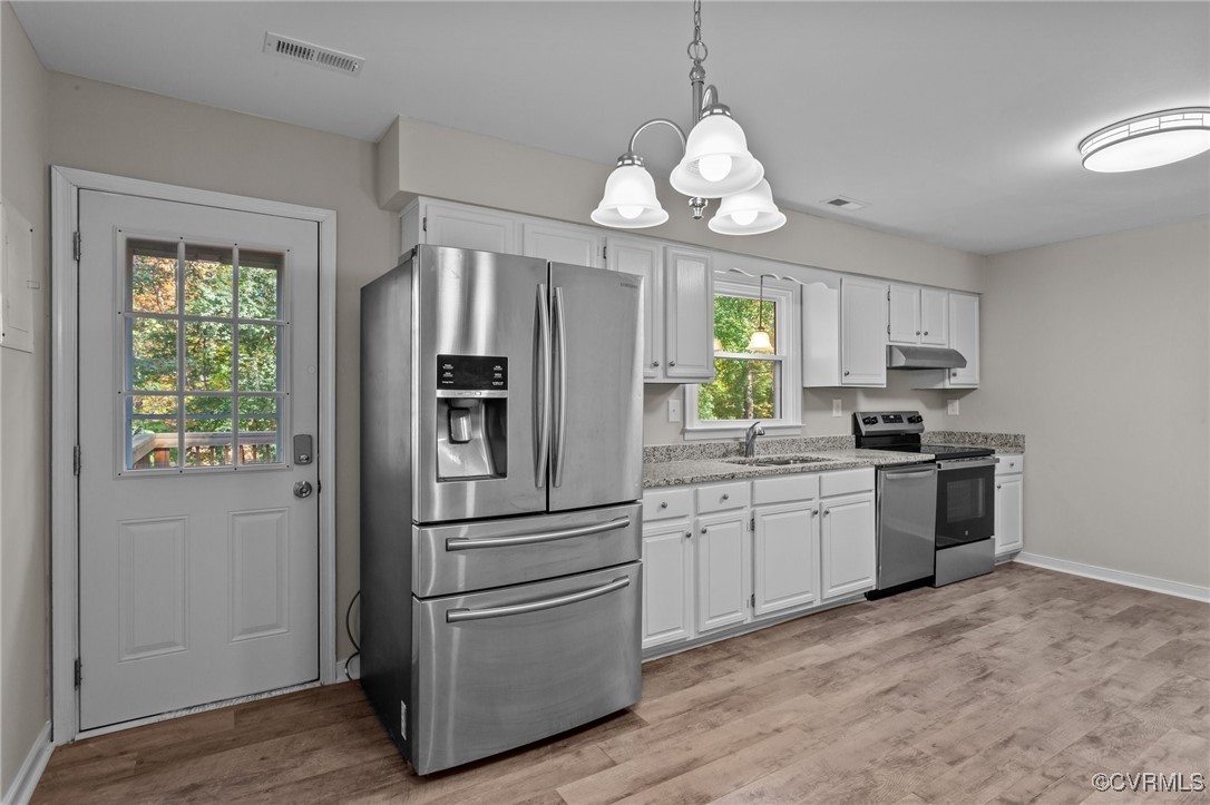 5237 Hallmark Drive Richmond, VA 23234 - Photo 10 of 44 a kitchen with stainless steel appliances granite countertop a refrigerator a stove a sink dishwasher a dining table and chairs with wooden floor