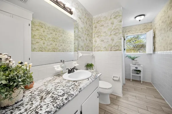 a bathroom with a granite countertop sink and a mirror