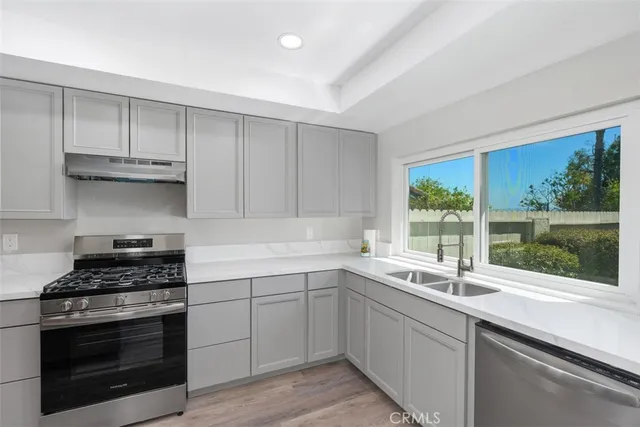 a kitchen with a sink stove top oven and cabinets