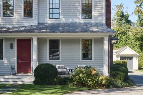 a view of a brick house with a yard and potted plants