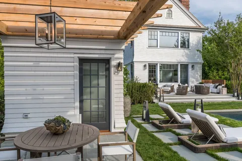 a view of a house with backyard sitting area and swimming pool