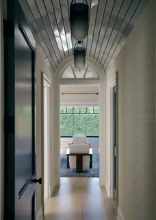 a bedroom with a bed and large windows