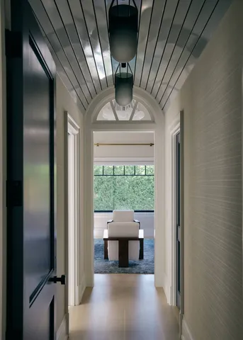 a bedroom with a bed and large windows