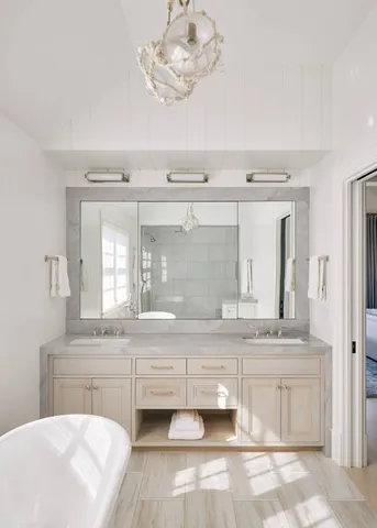 a white bath tub sitting in a bathroom next to a window