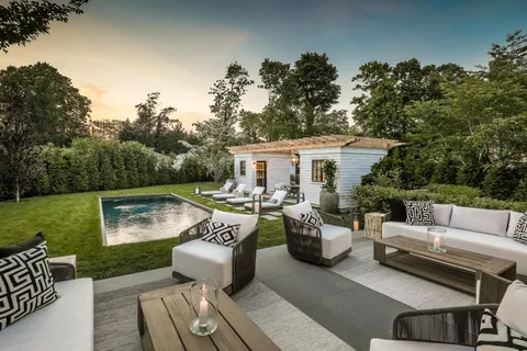 a view of a patio with couches fire pit and a table and chairs
