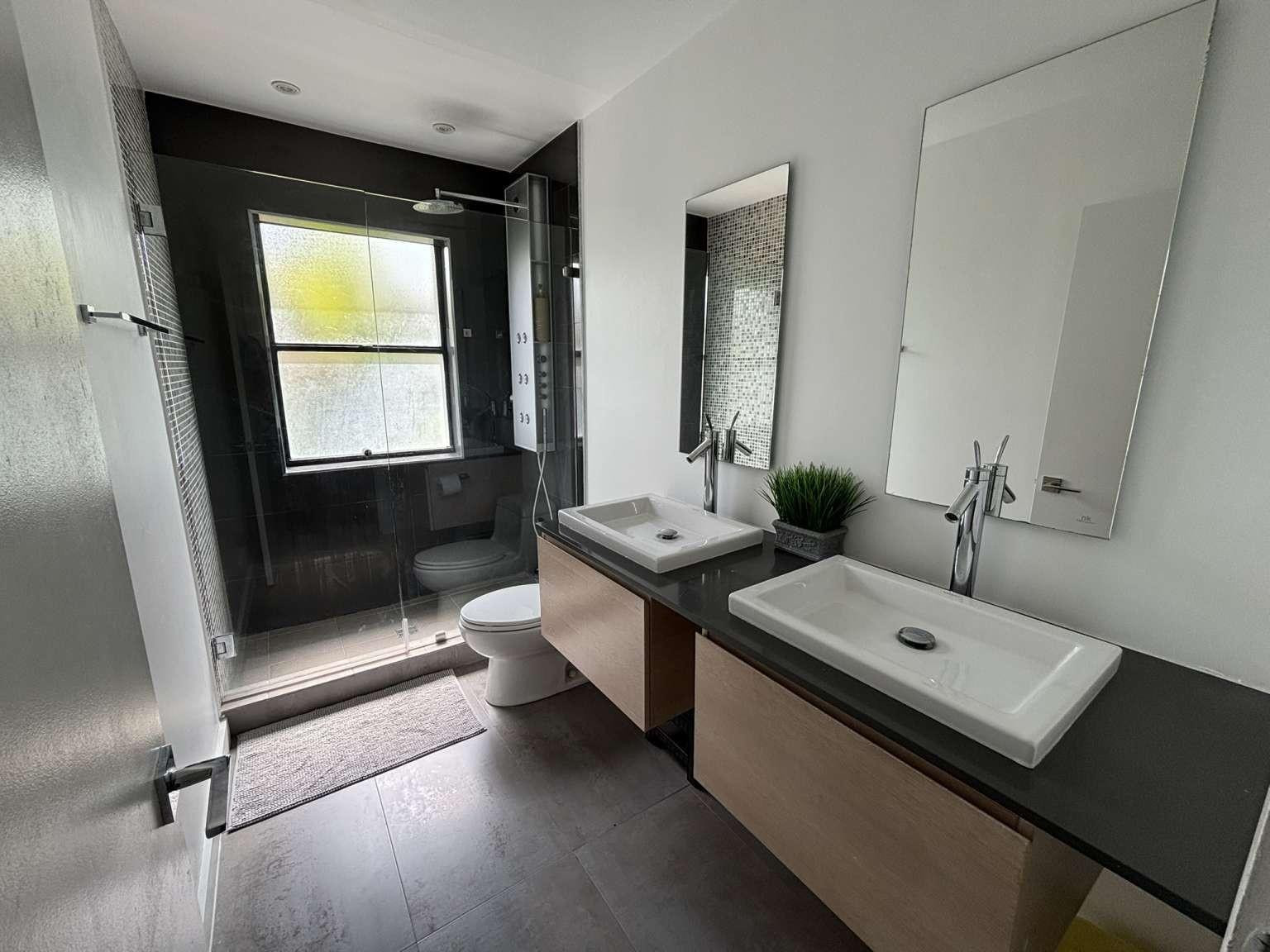 11119 Blue Coral Drive Boca Raton, FL 33498 - Photo 28 of 36 a bathroom with a double vanity sink toilet and mirror