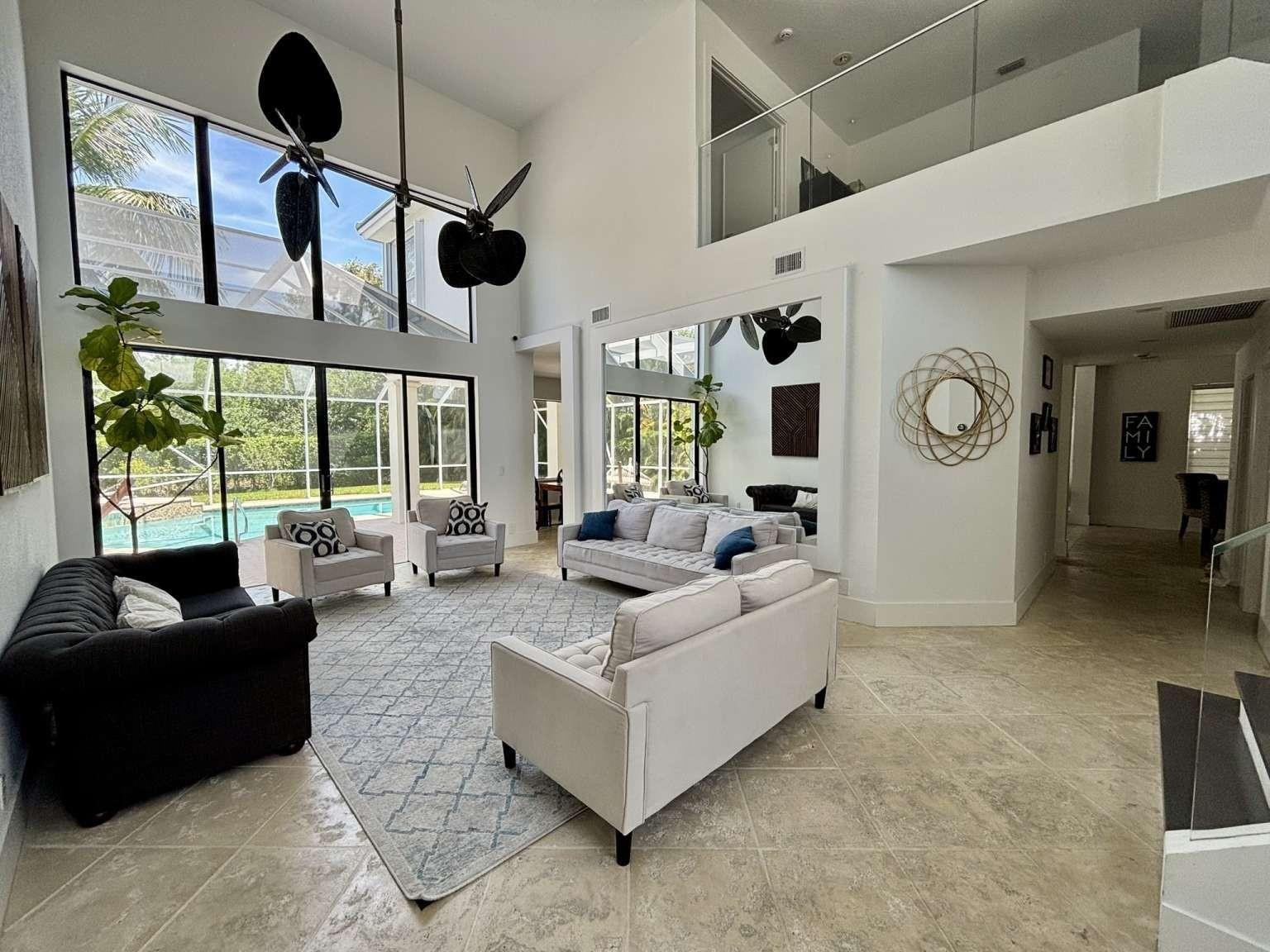 11119 Blue Coral Drive Boca Raton, FL 33498 - Photo 6 of 36 a living room with patio fireplace furniture and a large window
