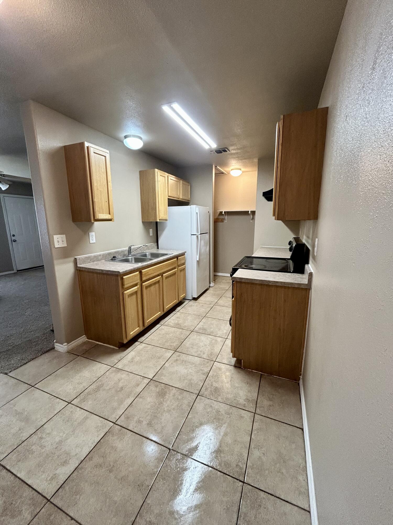 715 43rd Street, Unit 1&2 Lubbock, TX 79404 - Photo 5 of 13 a kitchen with stainless steel appliances a stove a sink and a refrigerator