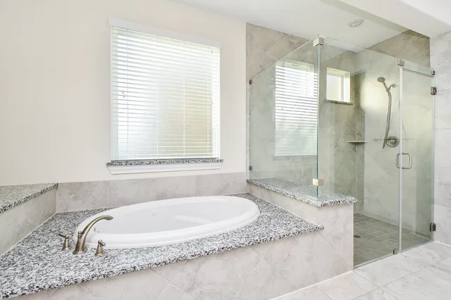 a spacious bathroom with a granite countertop tub sink and mirror