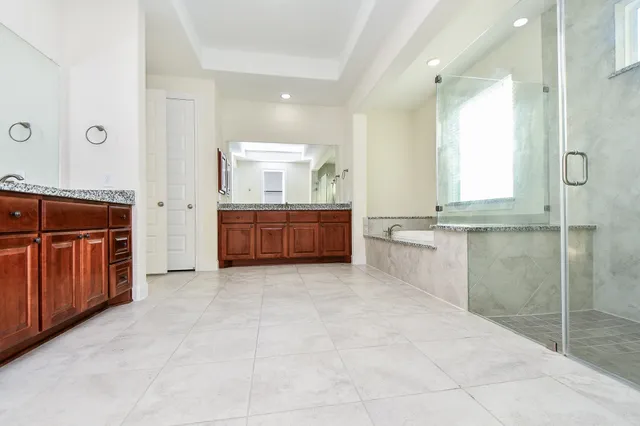 a bathroom with a granite countertop tub sink and mirror