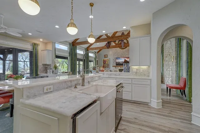 a kitchen with stainless steel appliances granite countertop a sink a stove and a wooden floors