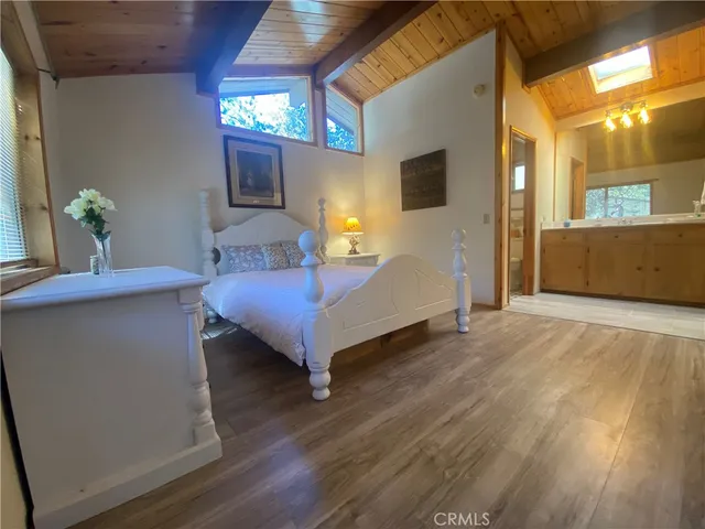 a bedroom with a bed and a flat tv screen on dresser