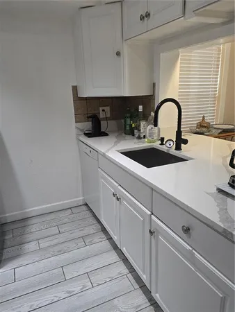 a close view of a sink and dishwasher with kitchen island