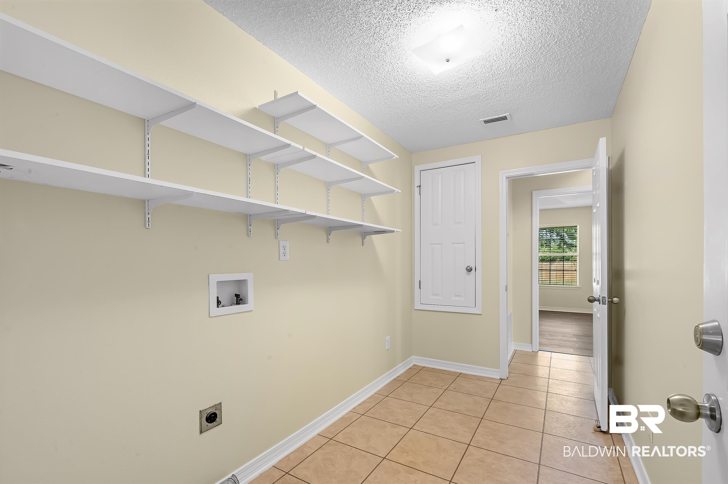 12443 Venice Boulevard Foley, AL 36535 - Photo 38 of 59 Washroom featuring hookup for a washing machine, light tile patterned floors, electric dryer hookup, and a textured ceiling