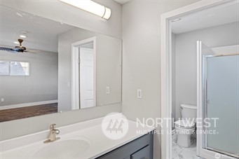 3306 Northeast 7th Place Renton, WA 98056 - Photo 10 of 11 a bathroom with a granite countertop sink a toilet and a large mirror