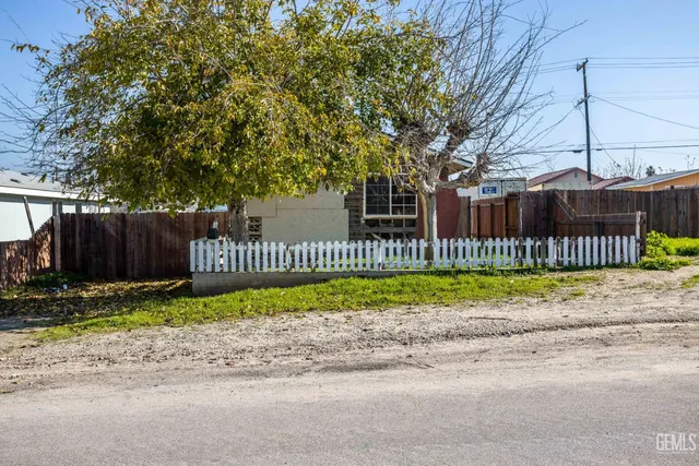 a view of a wooden fence next to a small yard