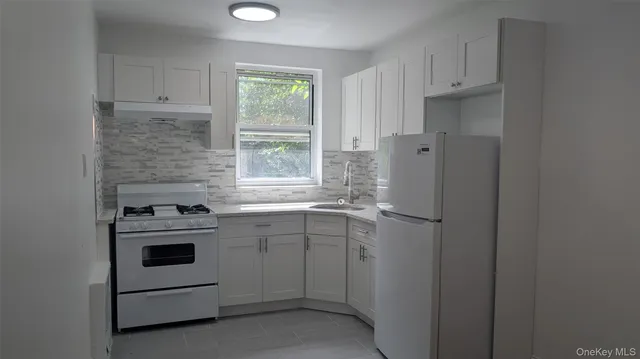 a kitchen with cabinets appliances and a window
