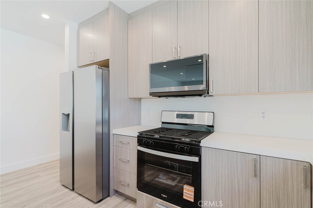 17846 Rinaldi Street Granada Hills, CA 91344 - Photo 14 of 34 a kitchen with stainless steel appliances a stove microwave and refrigerator