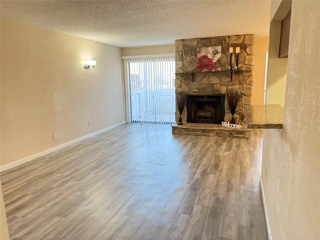 a view of a livingroom with wooden floor and a fireplace