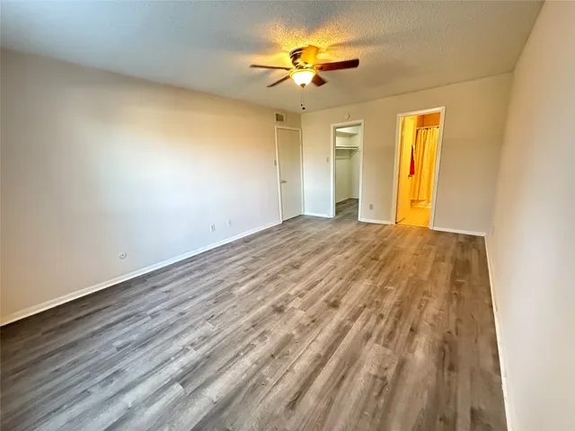 a view of a hallway with wooden floor and a window