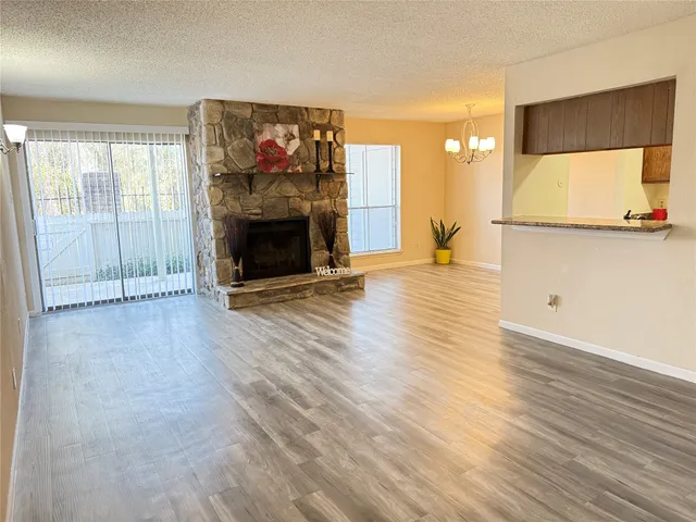 a view of a livingroom with wooden floor and a fireplace