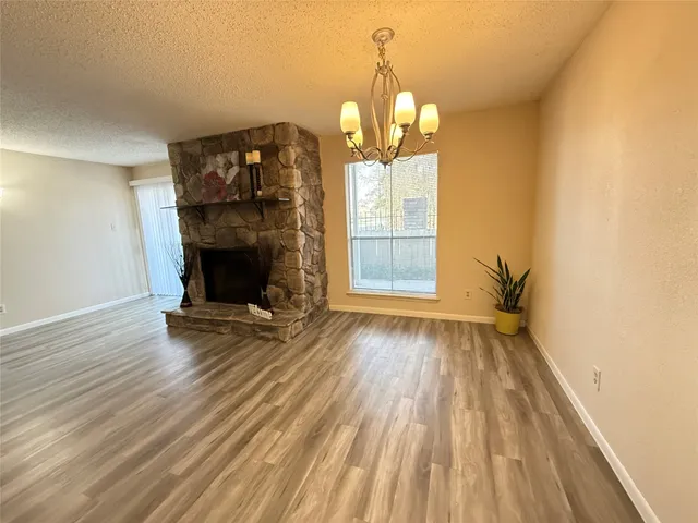 a view of empty room with wooden floor and fireplace
