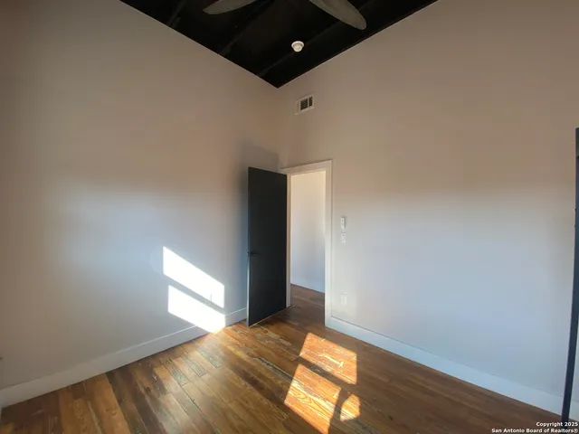 a view of empty room with wooden floor