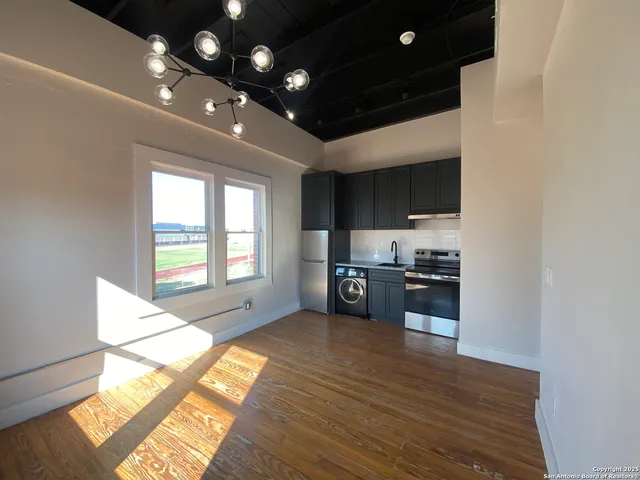 a open kitchen with stainless steel appliances a large counter top a stove and a refrigerator