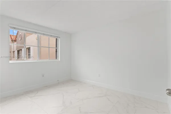 an empty room with windows and view of wooden floor