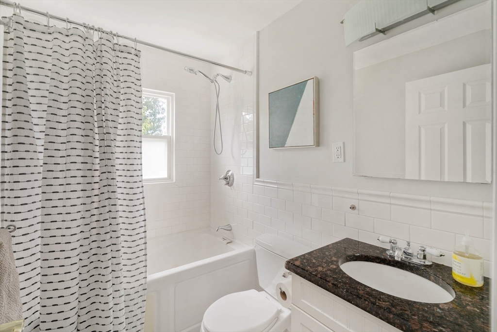 41 Wilson Avenue, Unit 41 Watertown, MA 02472 - Photo 17 of 22 a bathroom with a granite countertop sink toilet and shower