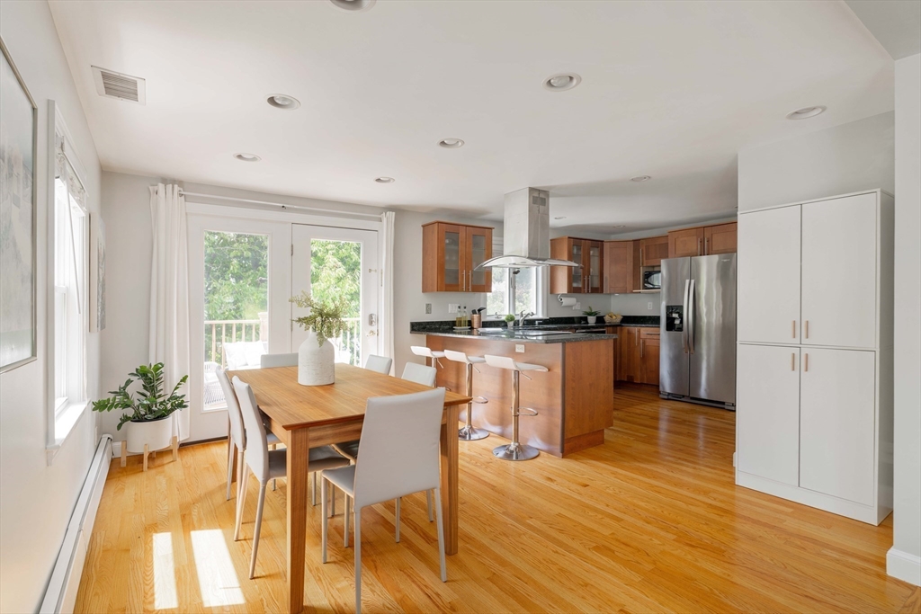 41 Wilson Avenue, Unit 41 Watertown, MA 02472 - Photo 3 of 22 a kitchen with a refrigerator a stove a dining table and chairs