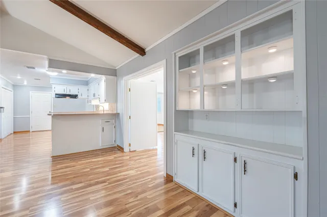 a view of empty room with wooden floor and window