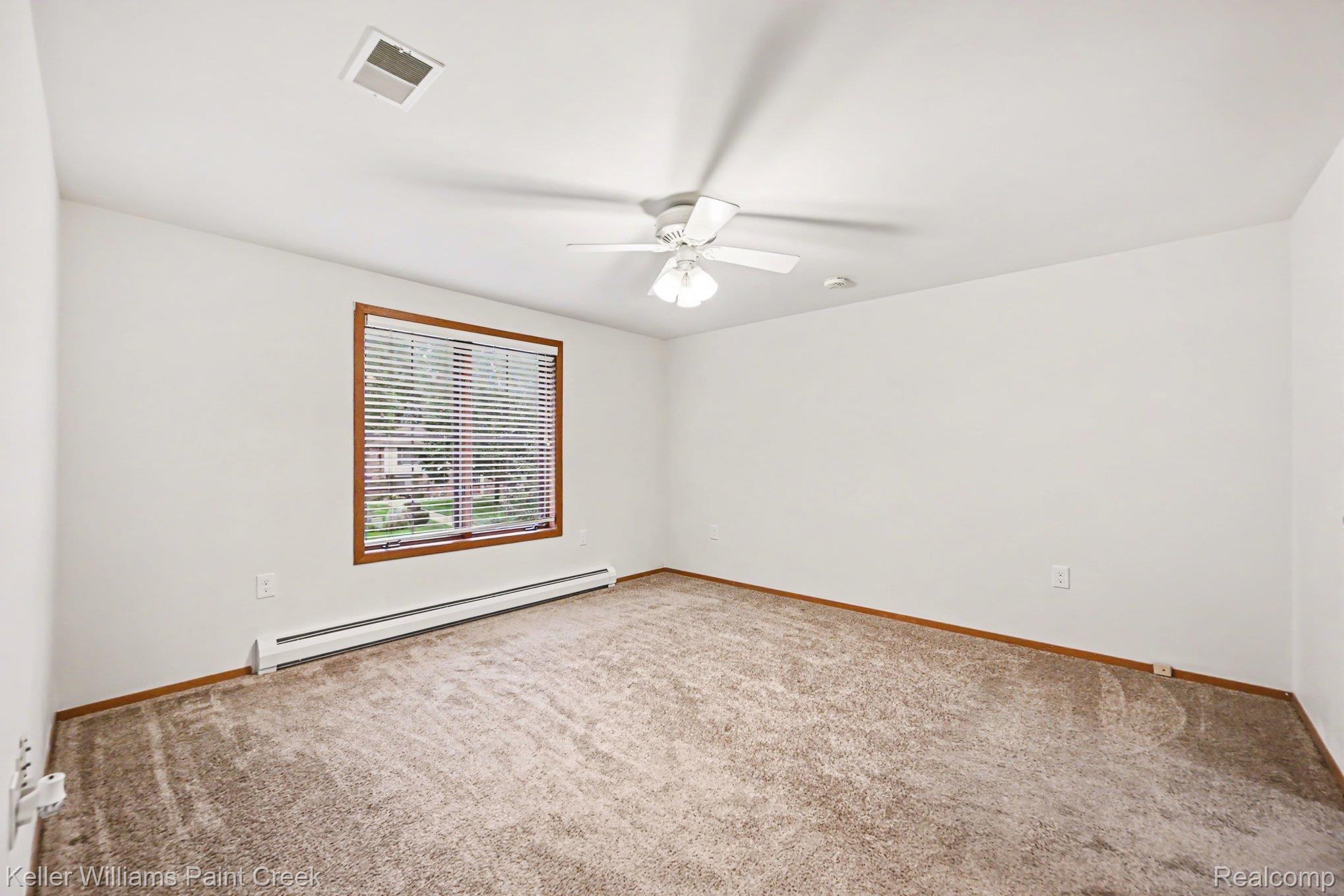 2232 London Bridge Drive Rochester, MI 48307 - Photo 17 of 26 Carpeted interior space featuring a window with wooden trim, horizontal blinds, and a white ceiling fan with integrated lighting