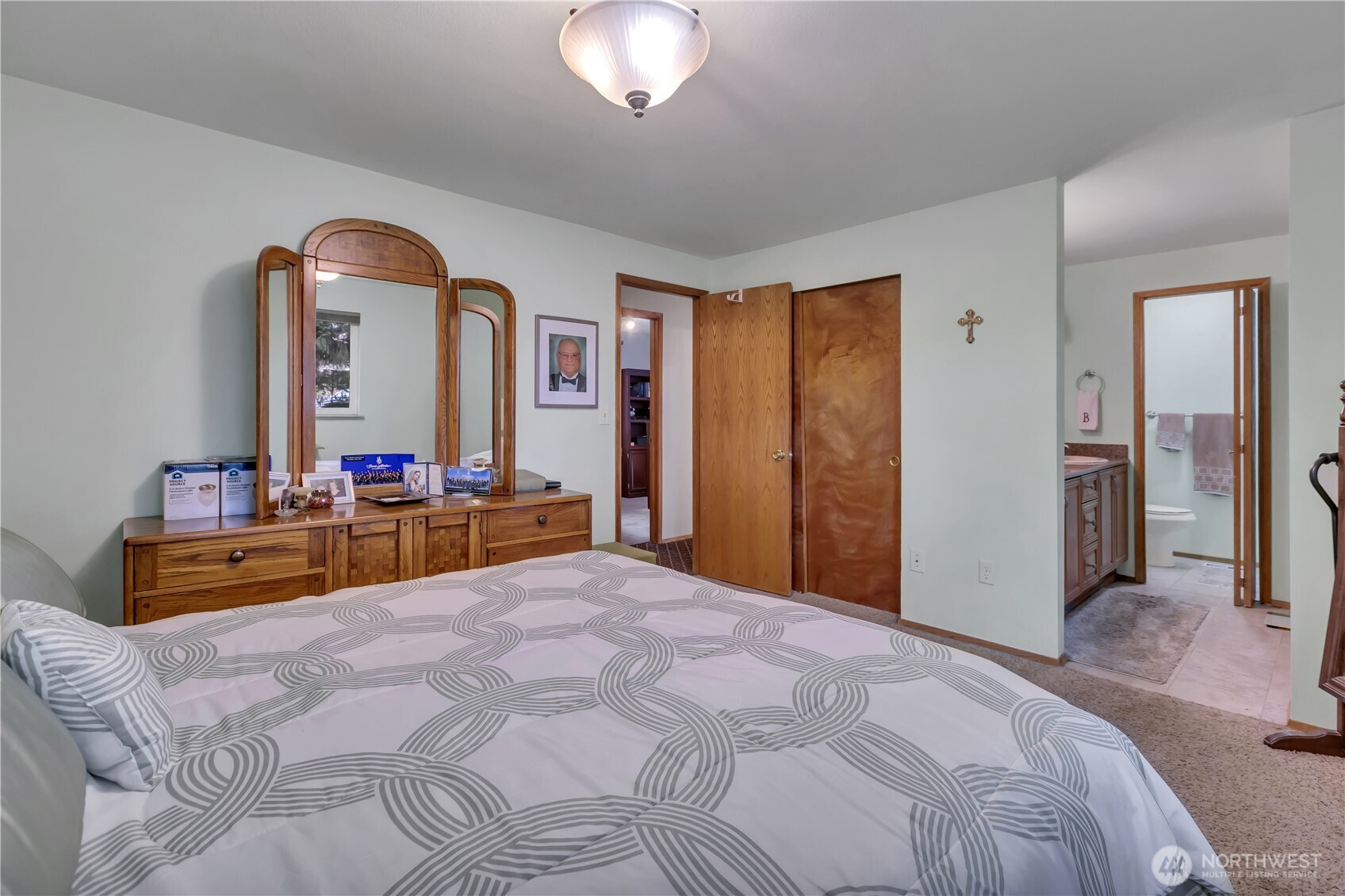 7316 Eustis Hunt Road Spanaway, WA 98387 - Photo 15 of 32 a bedroom with bed and a chandelier